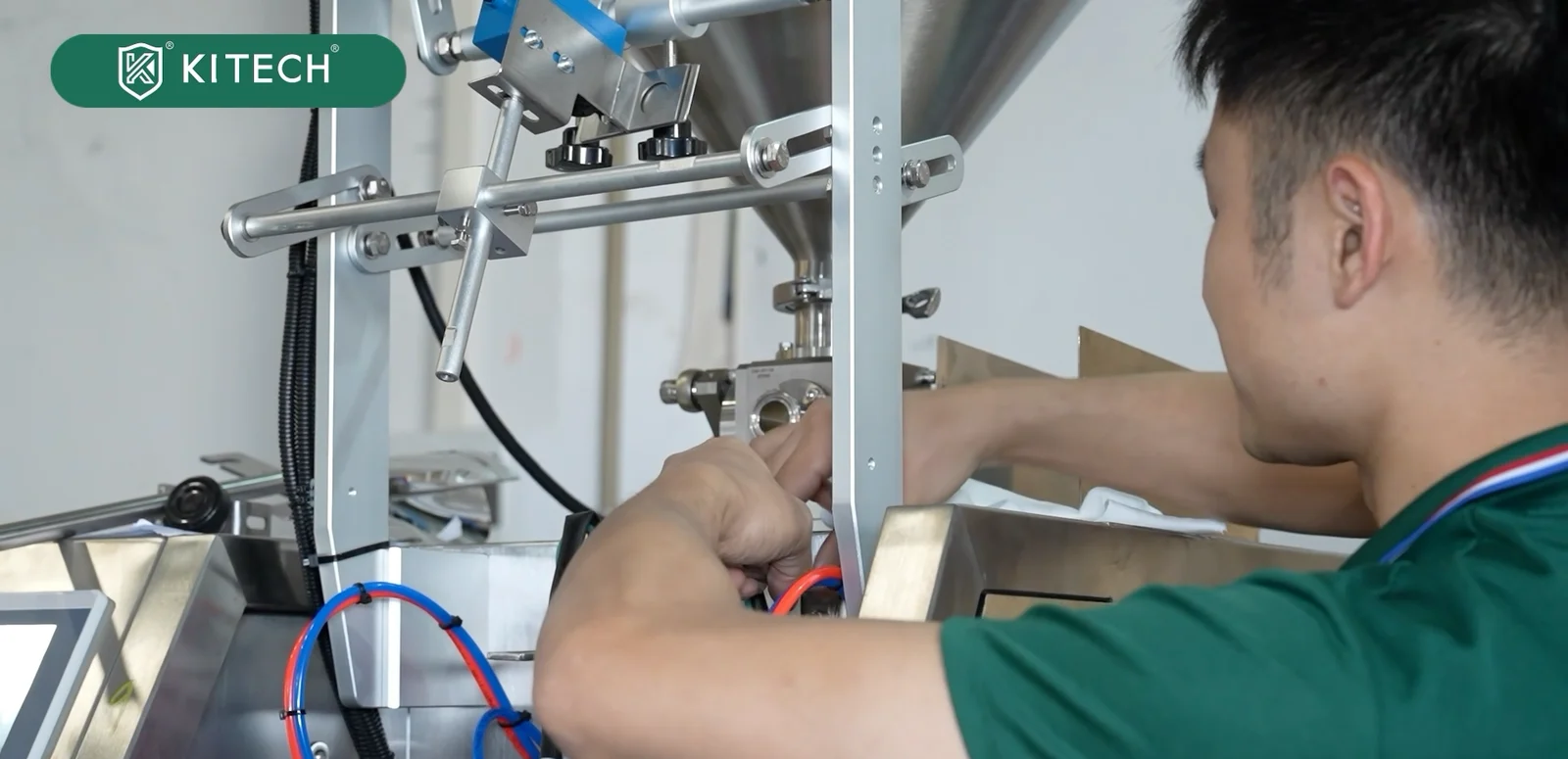 A worker making adjustments around the internal machine assembly